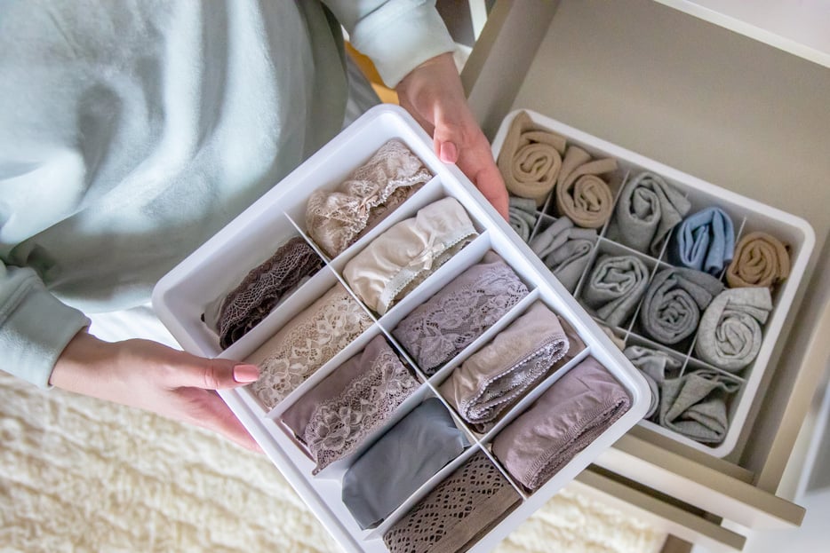 Top view female hands holding organizer drawer divider with socks storage Marie Kondo's method